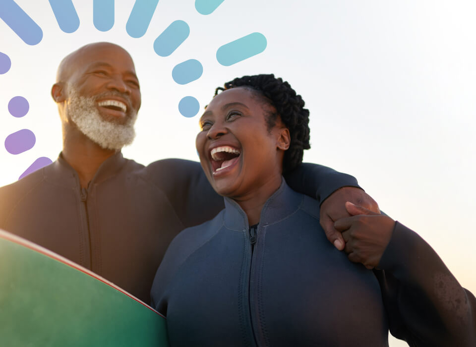 A man and woman smile together while holding a surfboard, showcasing their excitement for a day at the beach